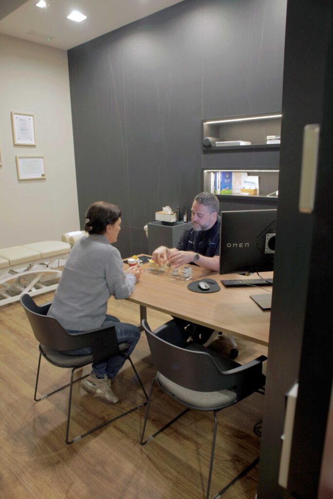 consulta-cliente-almeria-quiropractica Quiropráctico atendiendo a una cliente durante una consulta en Almería Quiropráctica