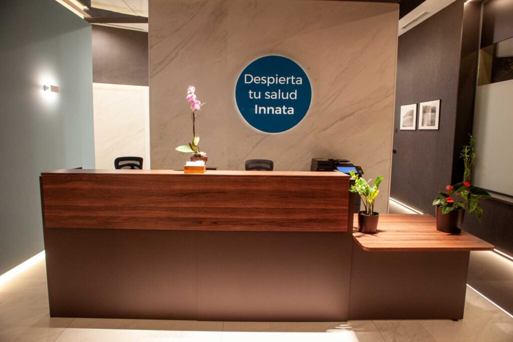 recepcion-centro-almeria-quiropractica Mostrador de recepción de Almería Quiropráctica con el mensaje Despierta tu salud innata